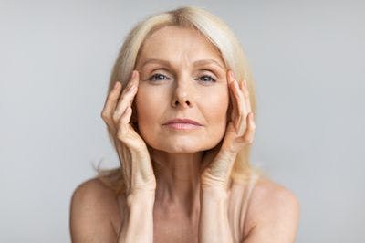 Antiage skincare woman touching her face