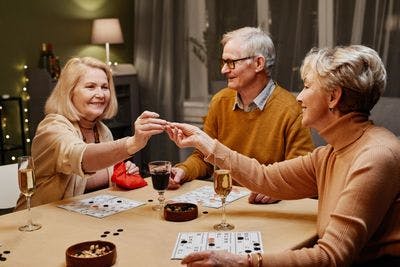 Group of old people play board game