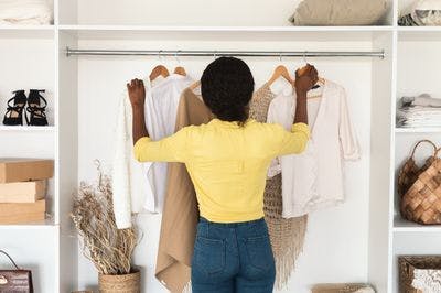 Woman choosing clothes from closet 