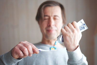 Man applying toothpaste to his toothbrush