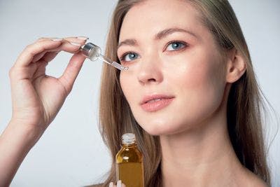 Woman applying serum to her face