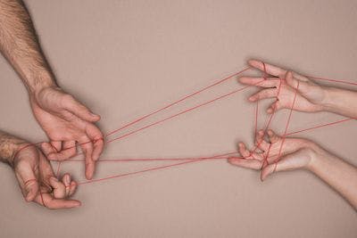 Man and woman holding red string 